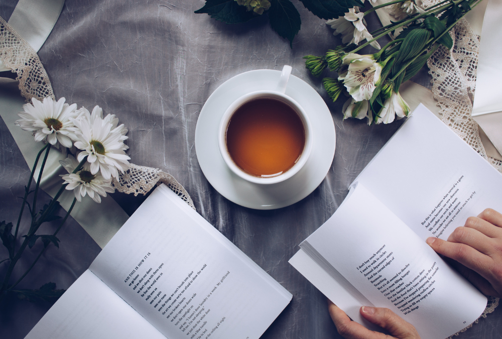 cup of coffee surrounded by flowers and an open book (all in neutral, calming colors)