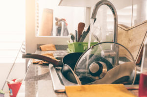 messy kitchen with sink overflowing with dishes