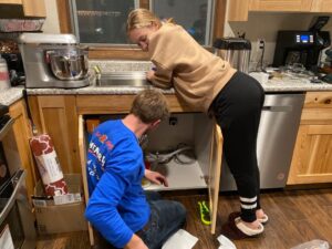 2 people fixing the sink